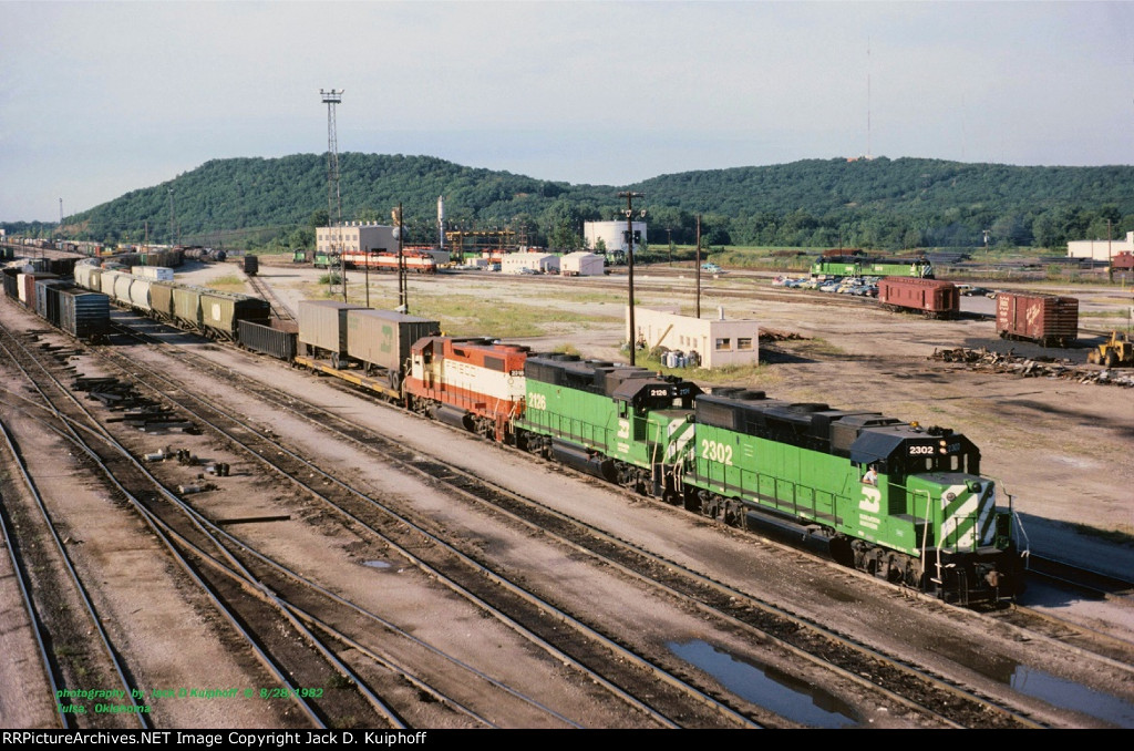 BN, Burlington Northern, ex-Frisco GP38-2s 2302-2126-2318, leaving the west end on the SL&SF Cherokee yard at Tulsa, Oklahoma. August 8, 1982. 